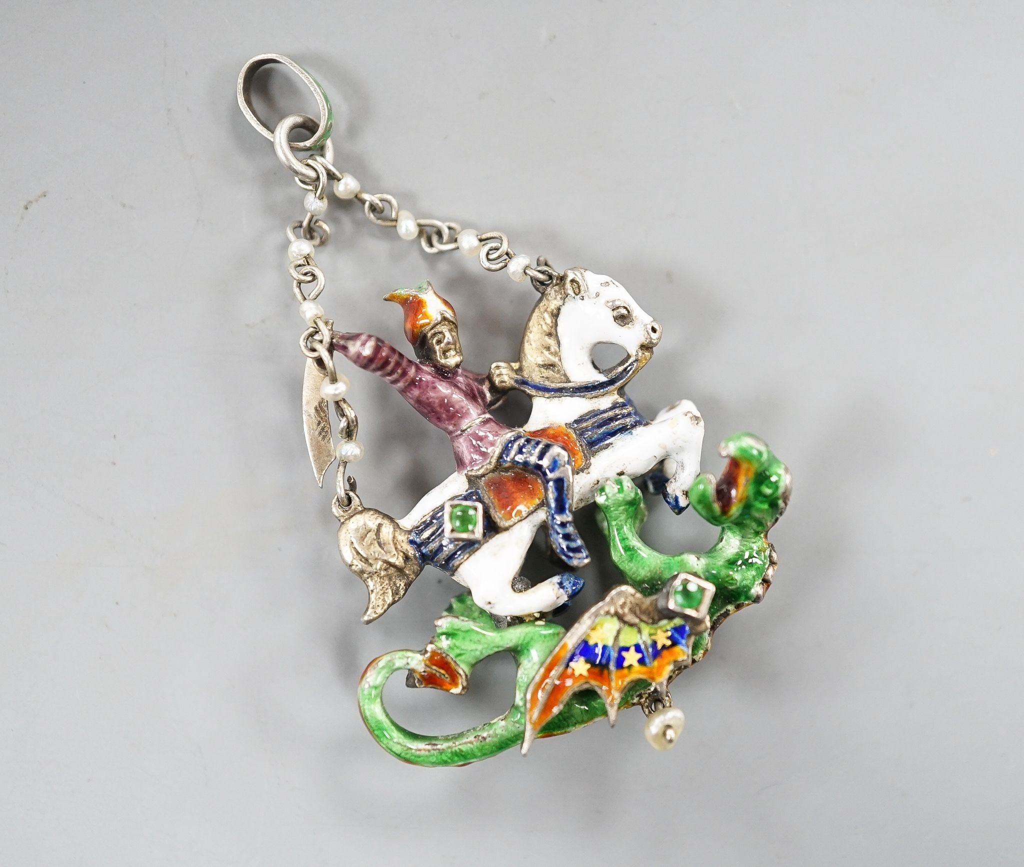 A 19th century Austro-Hungarian? gilt white metal, polychrome enamel, seed pearl and gem set 'St George & The Dragon' drop pendant, 4cm.